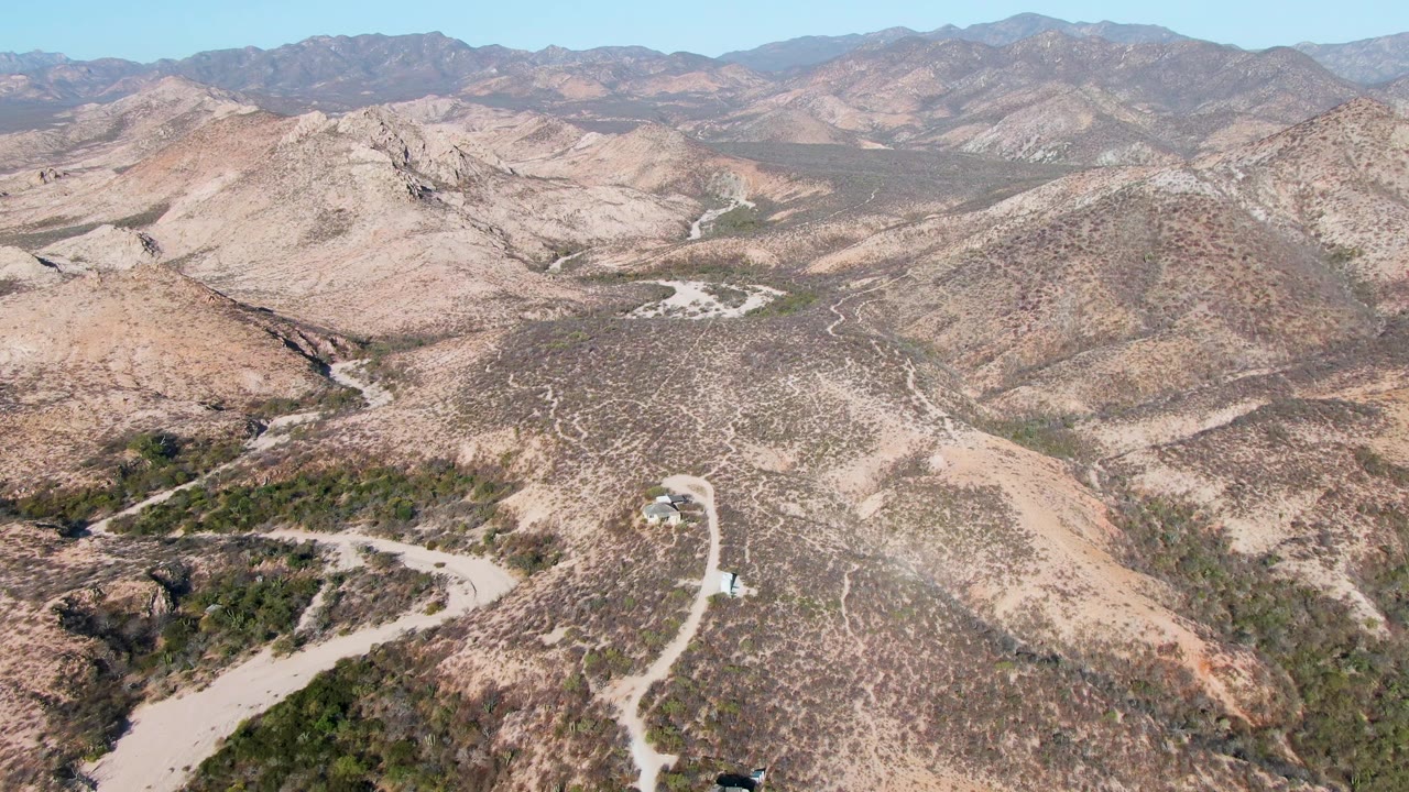 Aerial landscape of a winding dirt road crossing rocky hills