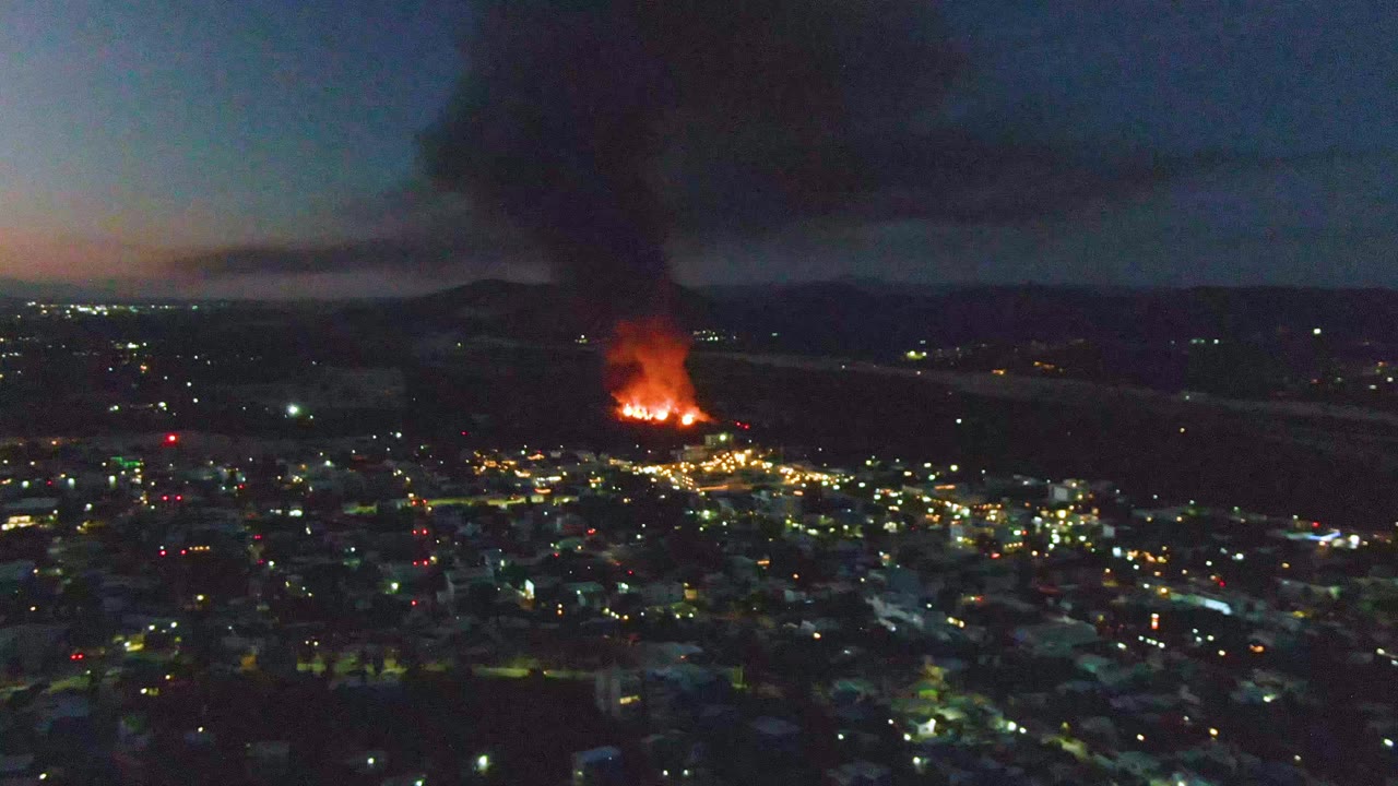 Dusk aerial of city with fire and heavy smoke