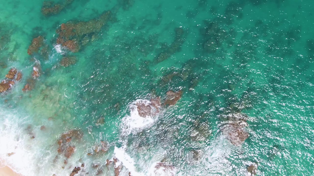 Overhead turquoise water with rocks and white surf near shore