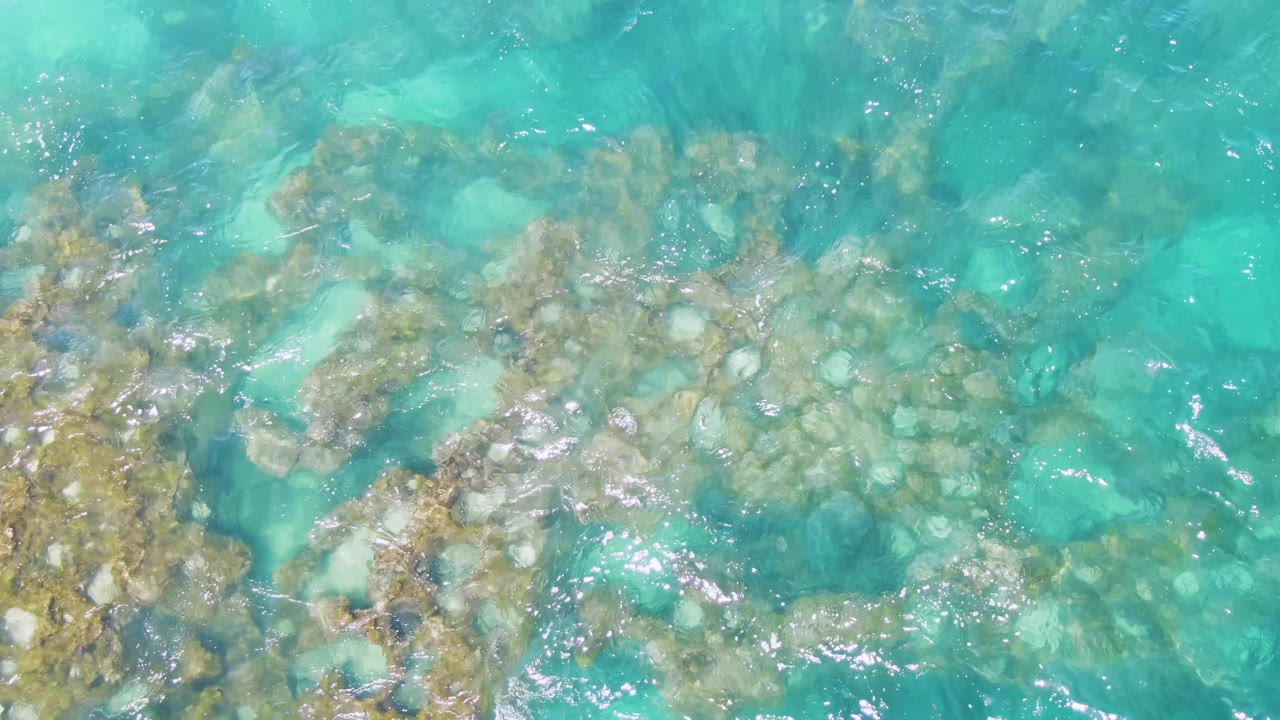 Shallow ocean water over rocks and sand