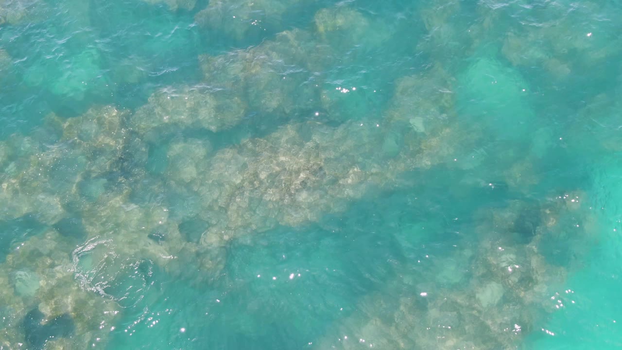 Clear turquoise water over submerged rocky seabed