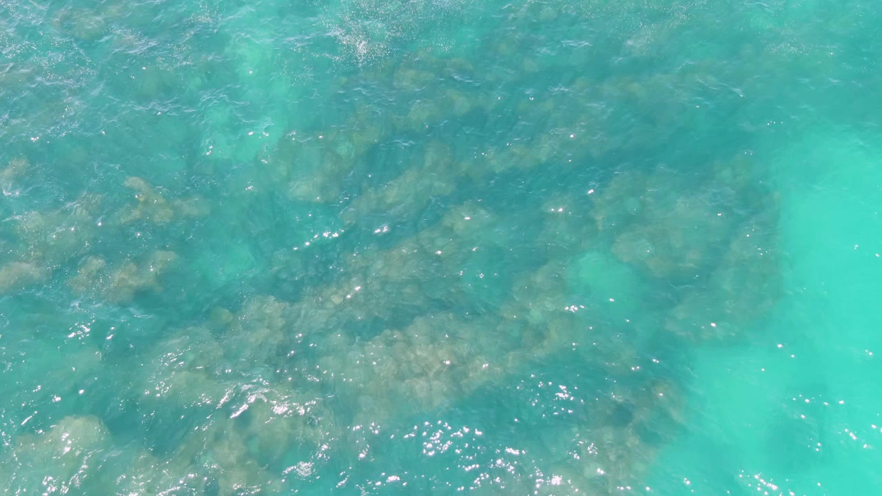 Clear water with rocky shapes below the surface