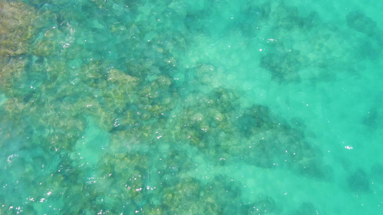 Shallow turquoise ocean over darker seabed