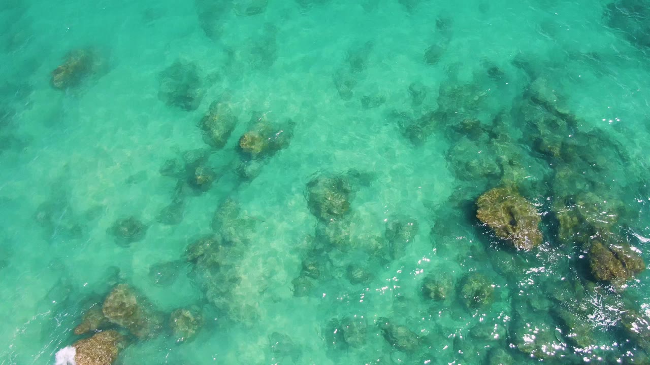 Turquoise shallow water over submerged rocks