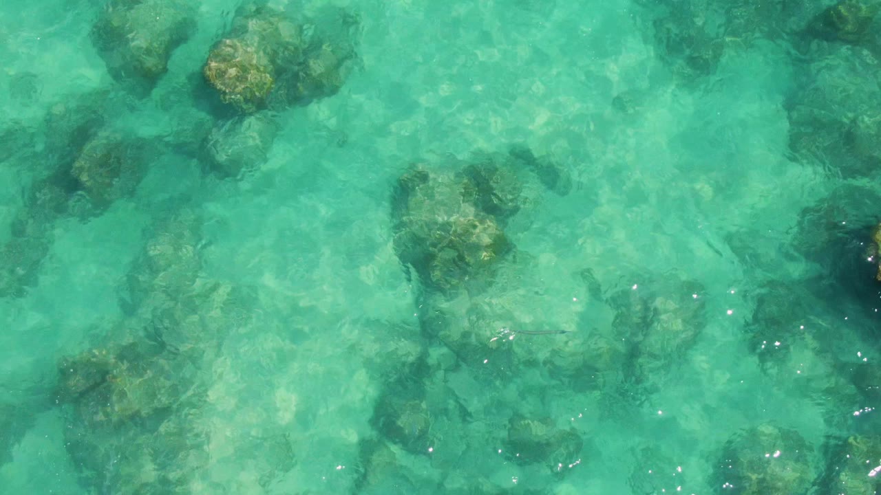 Turquoise shallow ocean water over submerged rocks