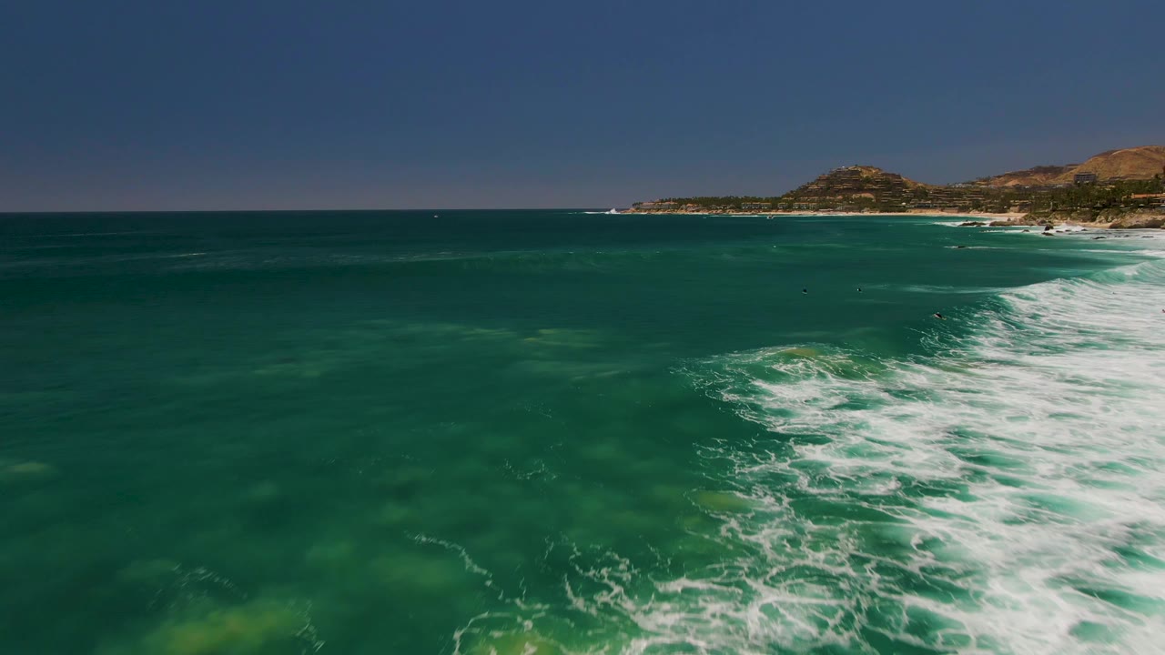 Aerial sea surface with surf foam and far shoreline