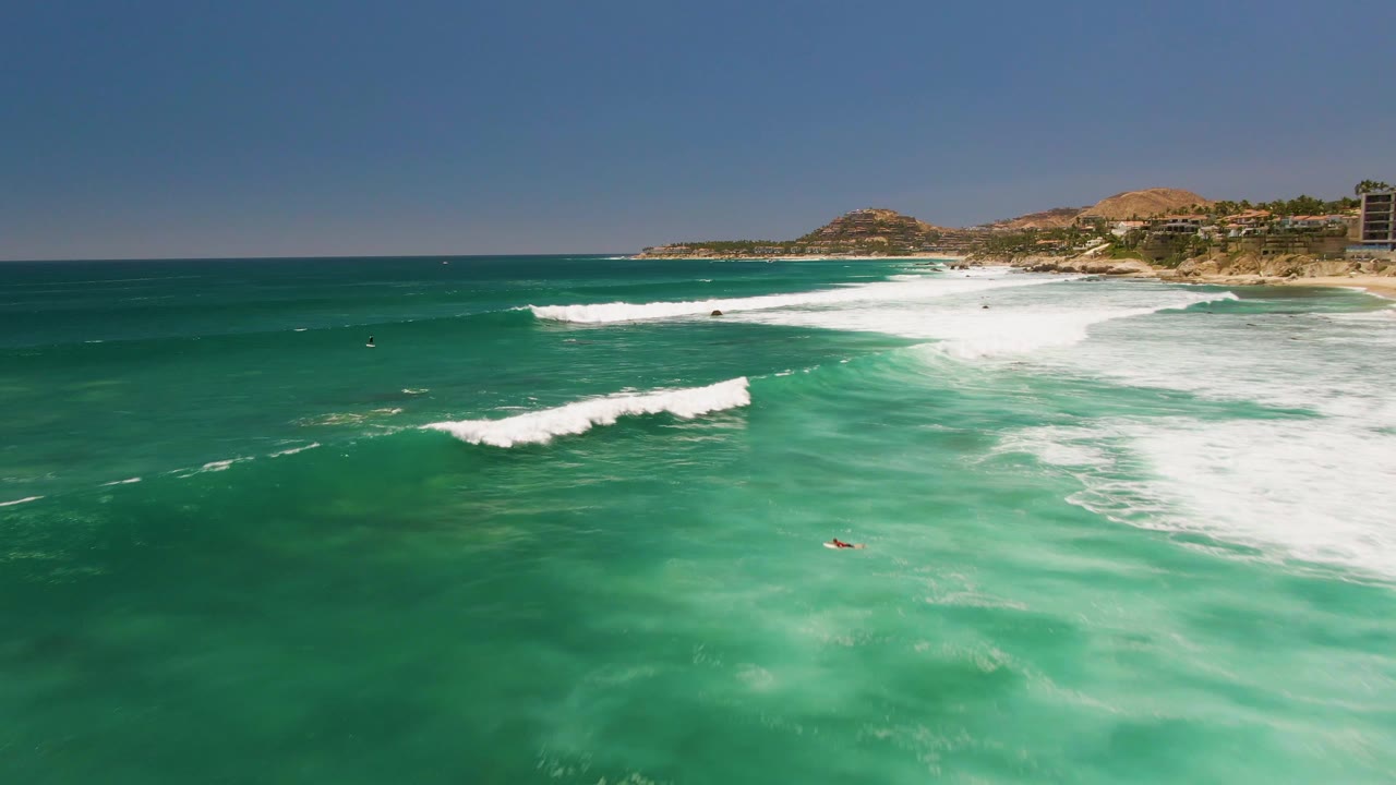 Breaking wave crossing open turquoise water near shore