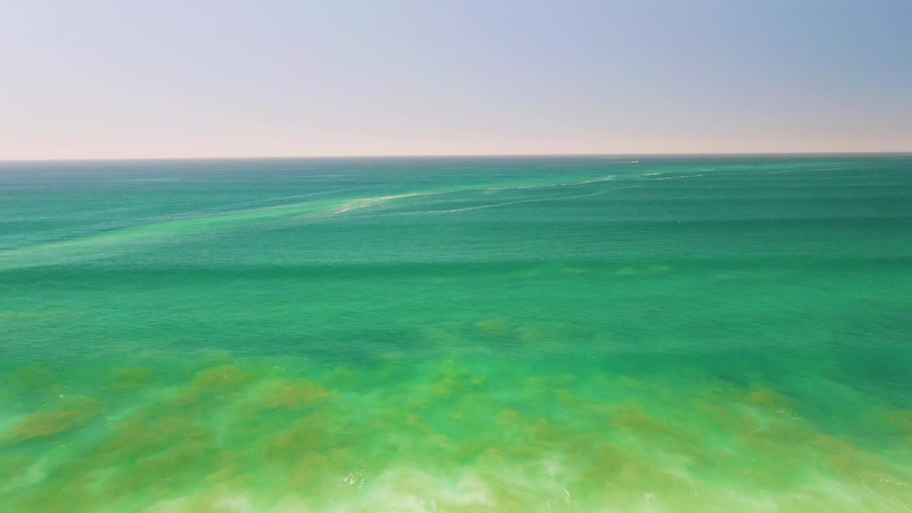 Opening frame of clear turquoise water over a shallow coral and sand seabed near San Jose del Cabo, with a flat horizon and no visible people.