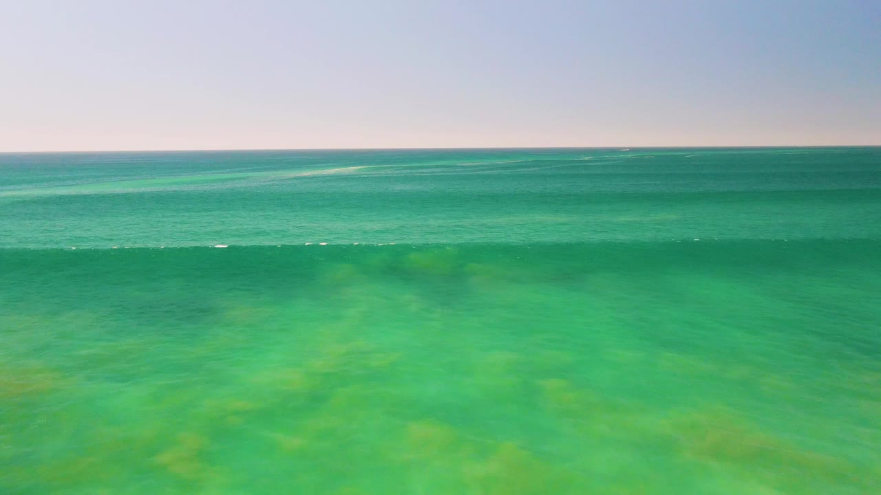 Calm turquoise water beneath a pale sky and horizon