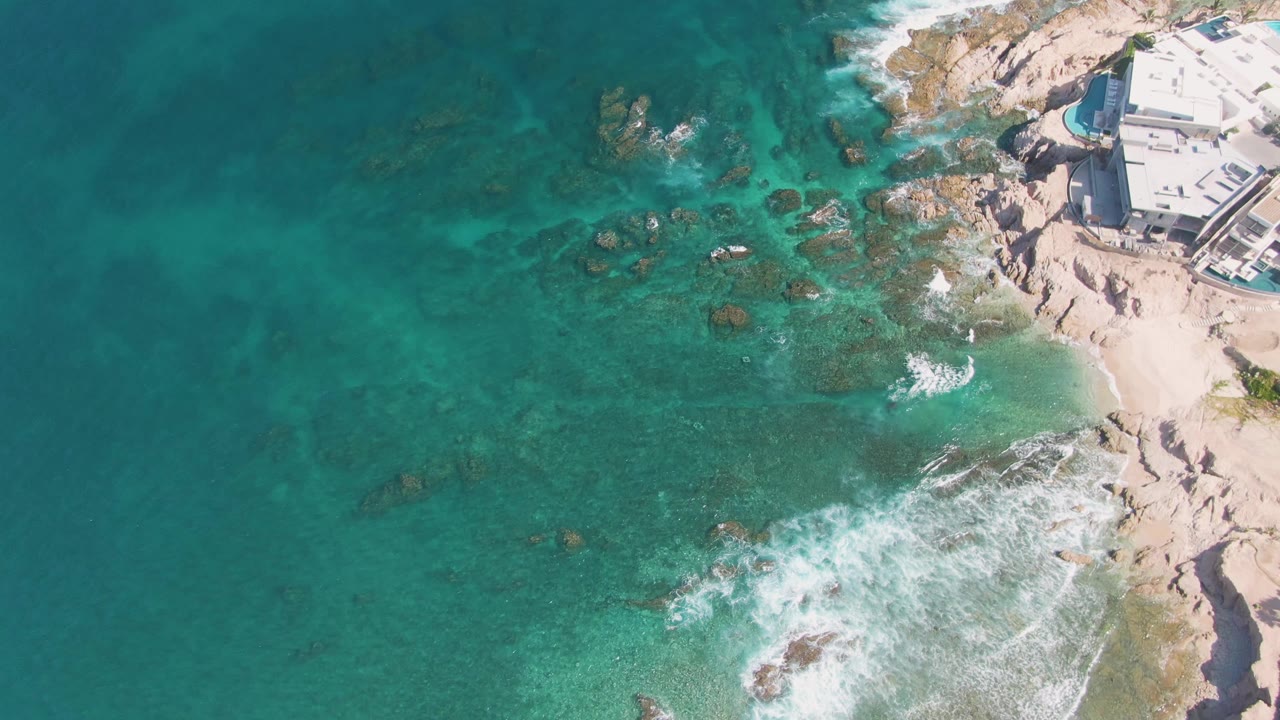 Turquoise water and waves beside a rocky sandy shore