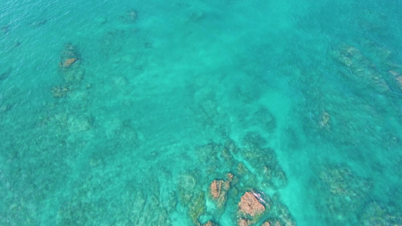 Shallow ocean water with scattered rocks and ripples