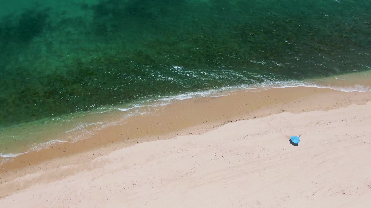 At 0:01, the Playa Miramar Los Cabos shoreline runs diagonally under green-blue water, with foam edging the sand and no visible people.