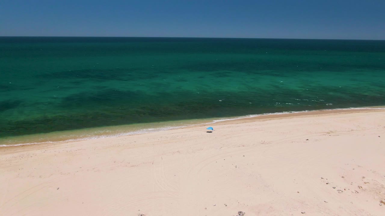 Aerial view of pale sand beach and turquoise ocean water