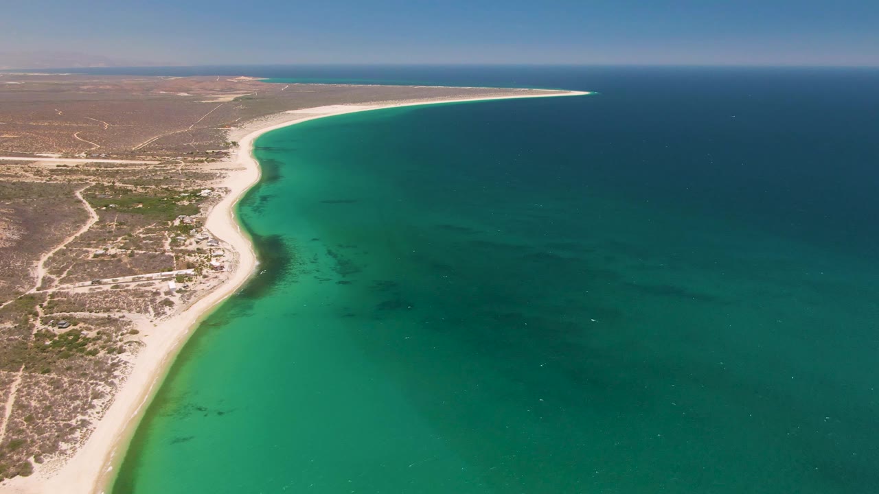 Aerial view of curving sandy coastline and turquoise ocean water