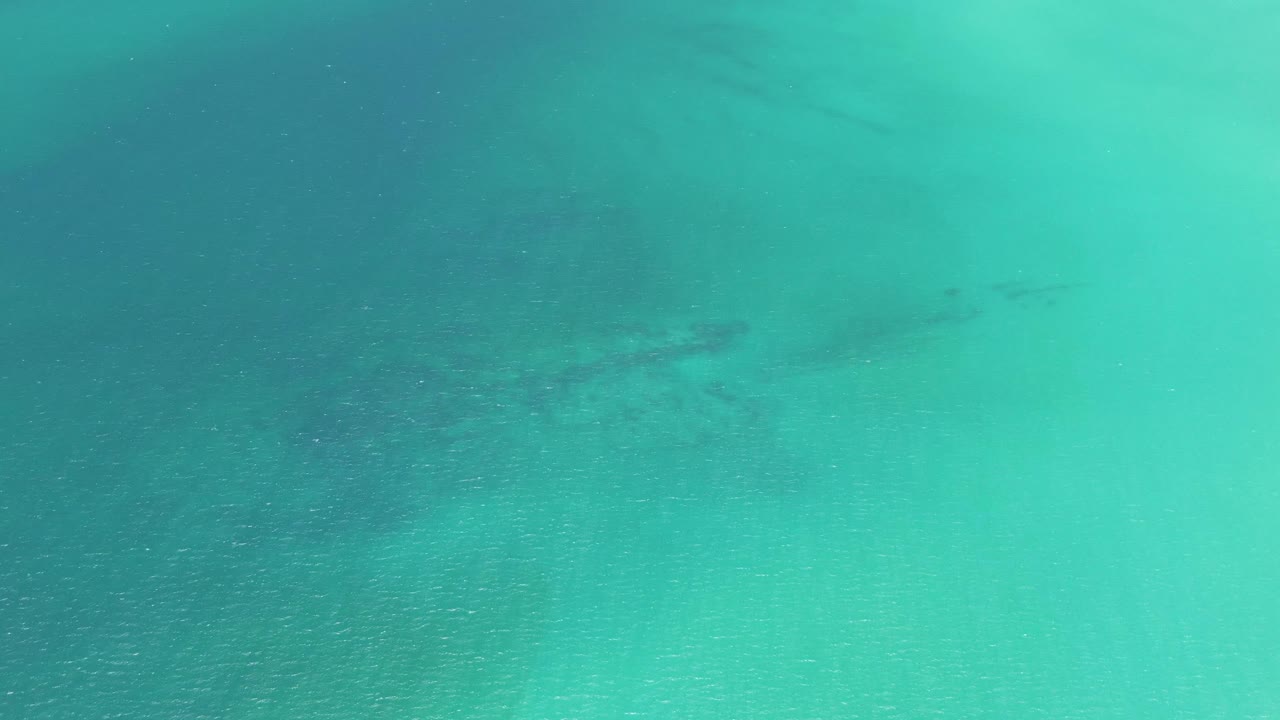 Turquoise shallow ocean water over sandy seabed