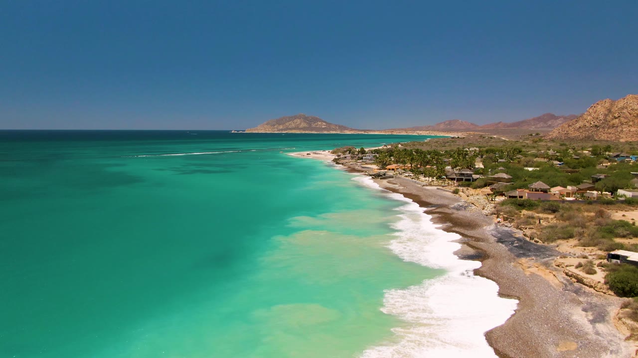 Aerial coastline with open turquoise water and a diagonal beach.