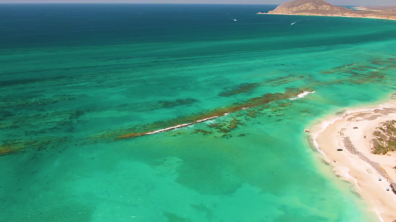 Turquoise coastal water with sand at the right edge