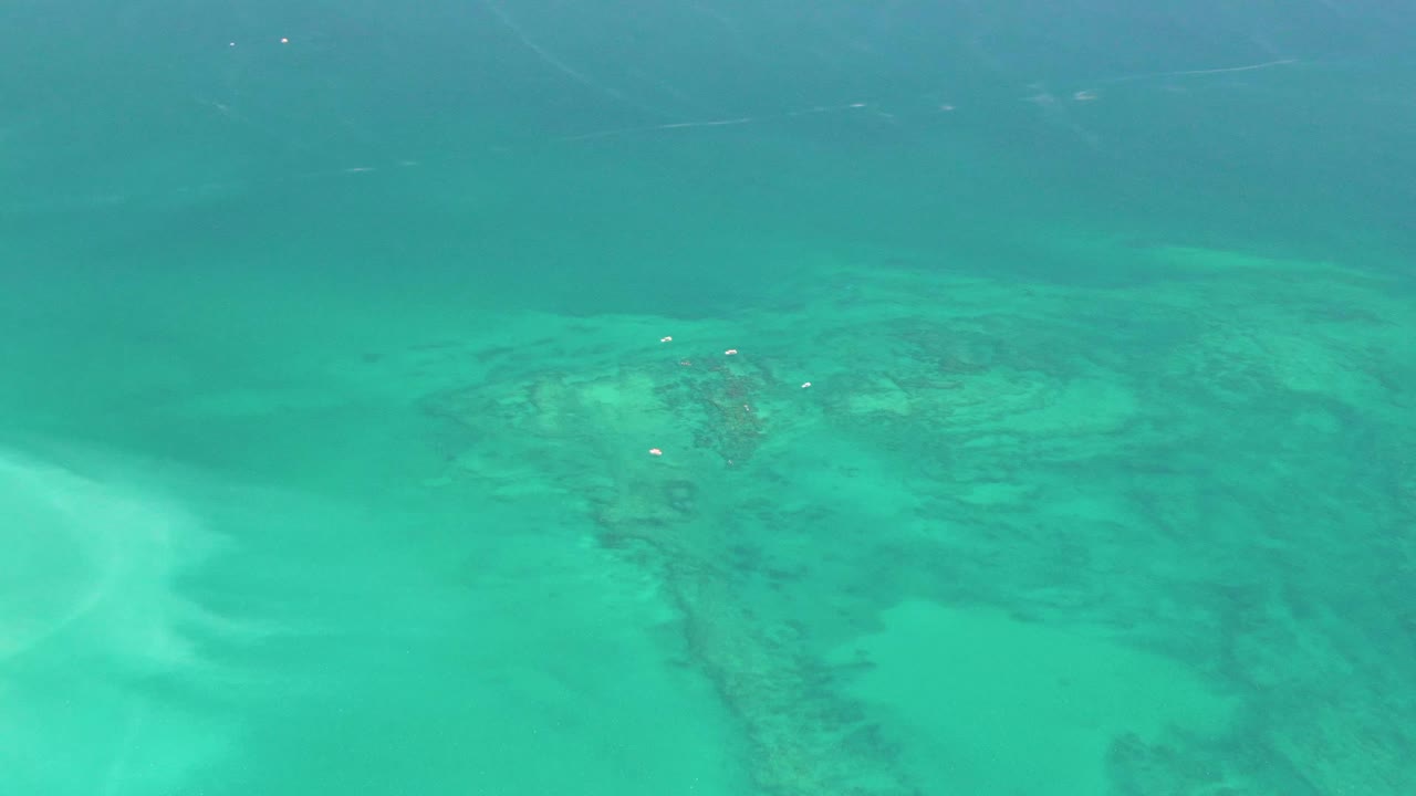 Opening frame of clear turquoise water above pale sand and darker seabed patches in Cabo Pulmo, with no visible people.