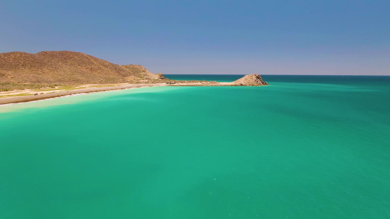 Aerial coast view with clear green-blue water and rocky point