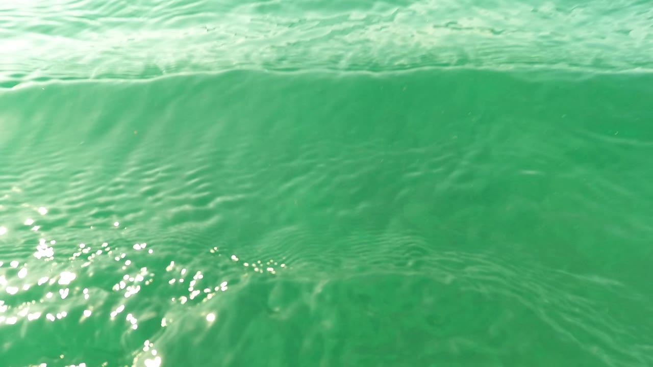 Ocean surface seen from water level with green ripples