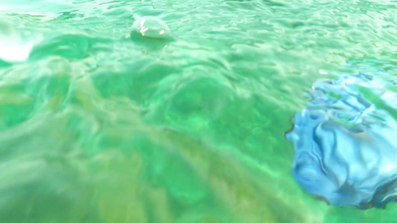 At the start of the Los Barriles clip, rippled turquoise water fills the frame with a small fish near the surface and no visible people.