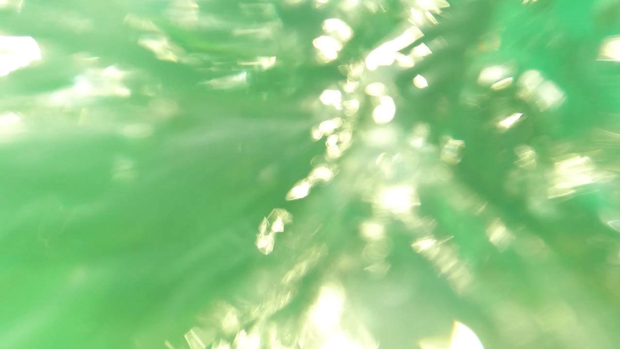 Blurred underwater green water with strong sunlight glare