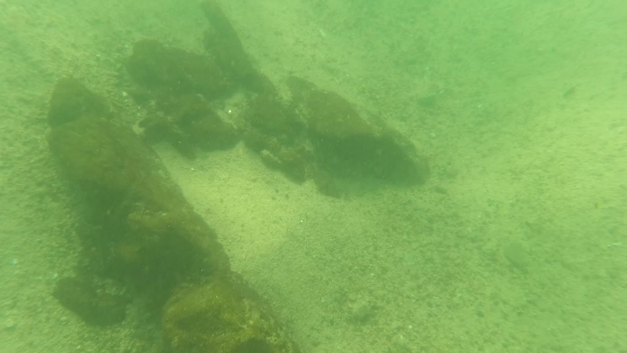 Underwater structure fading into green water over sand