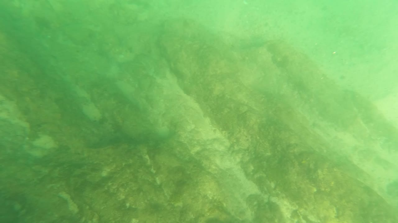 Submerged rocks appear softer and more blurred in green water at Los Barriles, with no visible people or man-made objects.