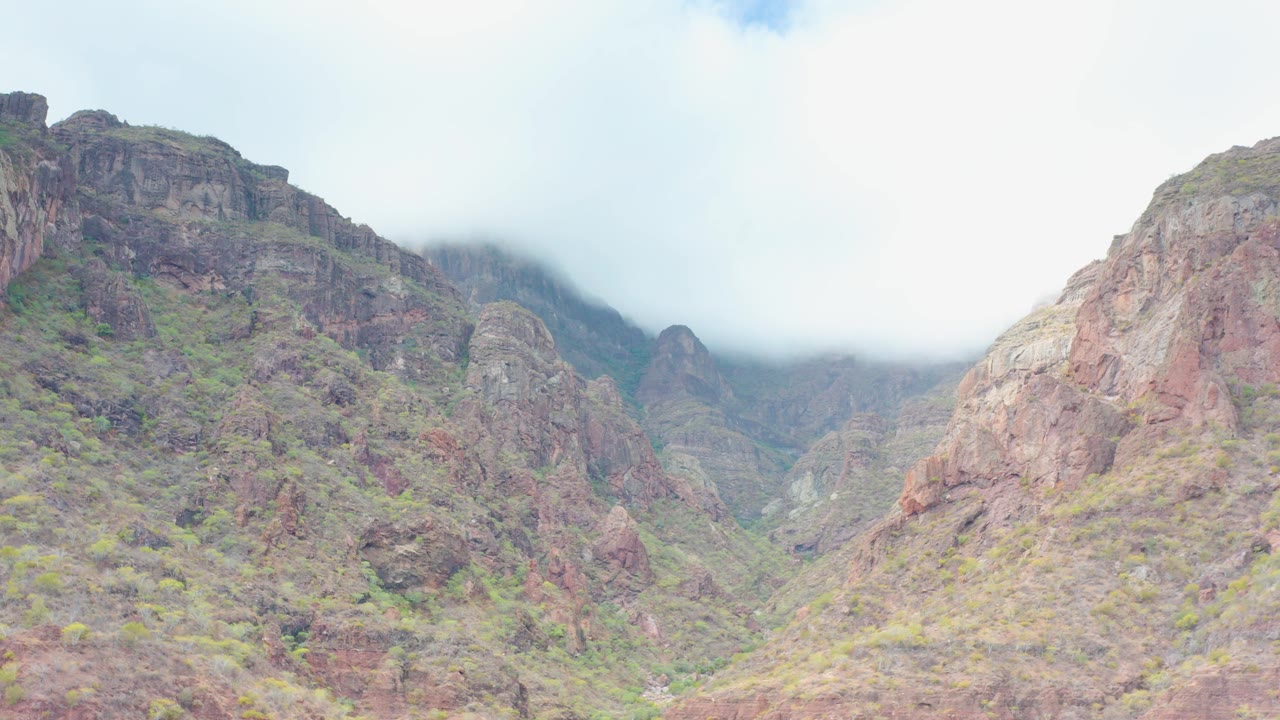 Rocky valley walls with cloud cover over distant peaks