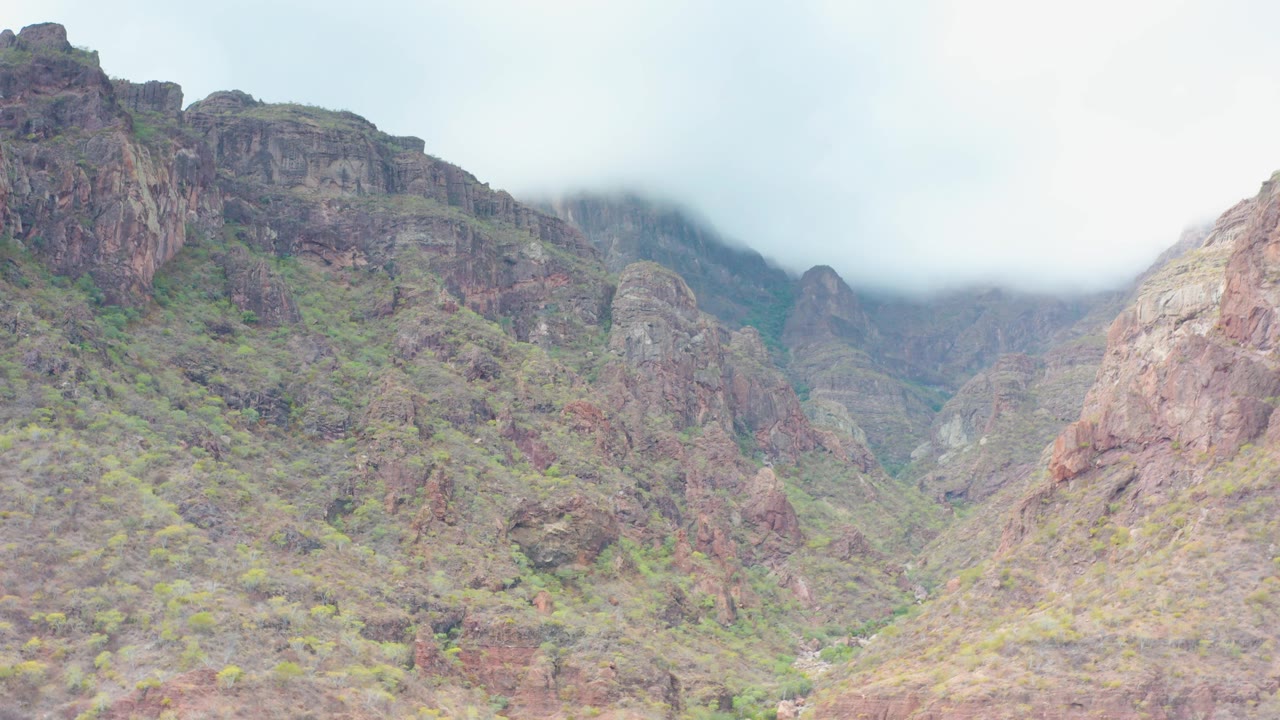 Overcast mountain valley with rocky walls and mist