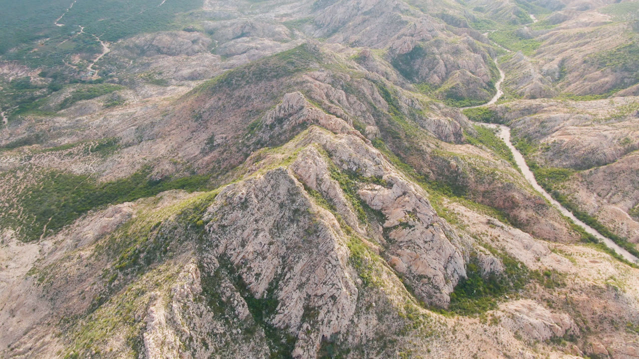 Overhead landscape of arid hills and a pale road