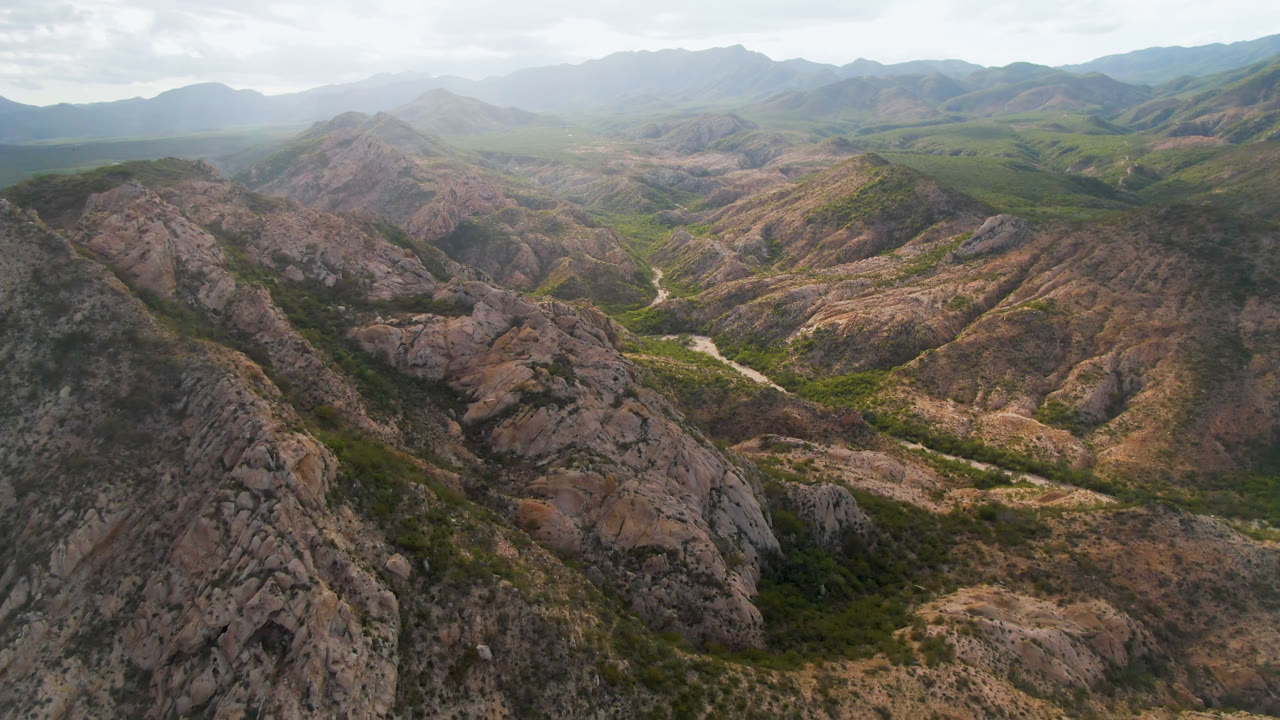 Rocky foreground ridge overlooking a winding valley road.