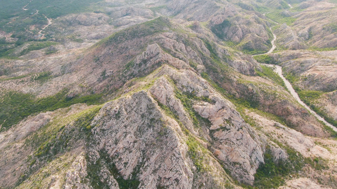Rocky hills seen from above with winding road through the center right