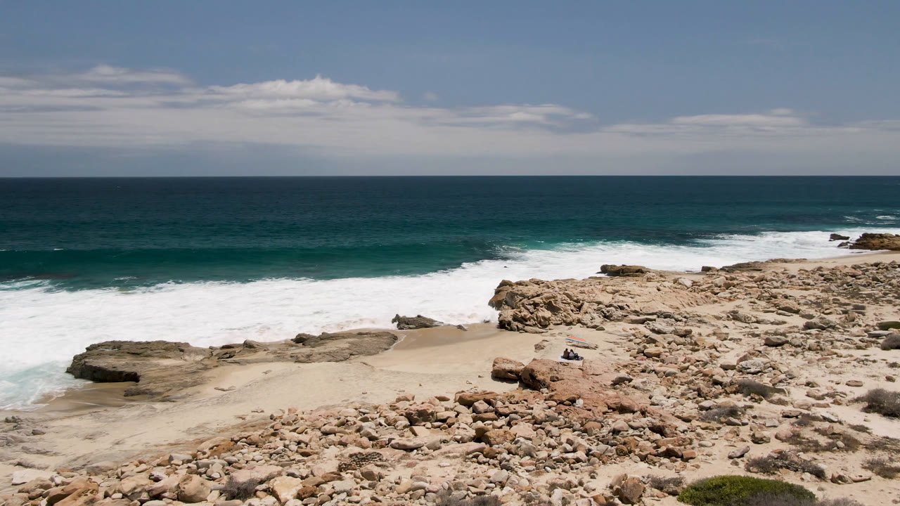 Rocky Baja California Sur coast with waves breaking on sand