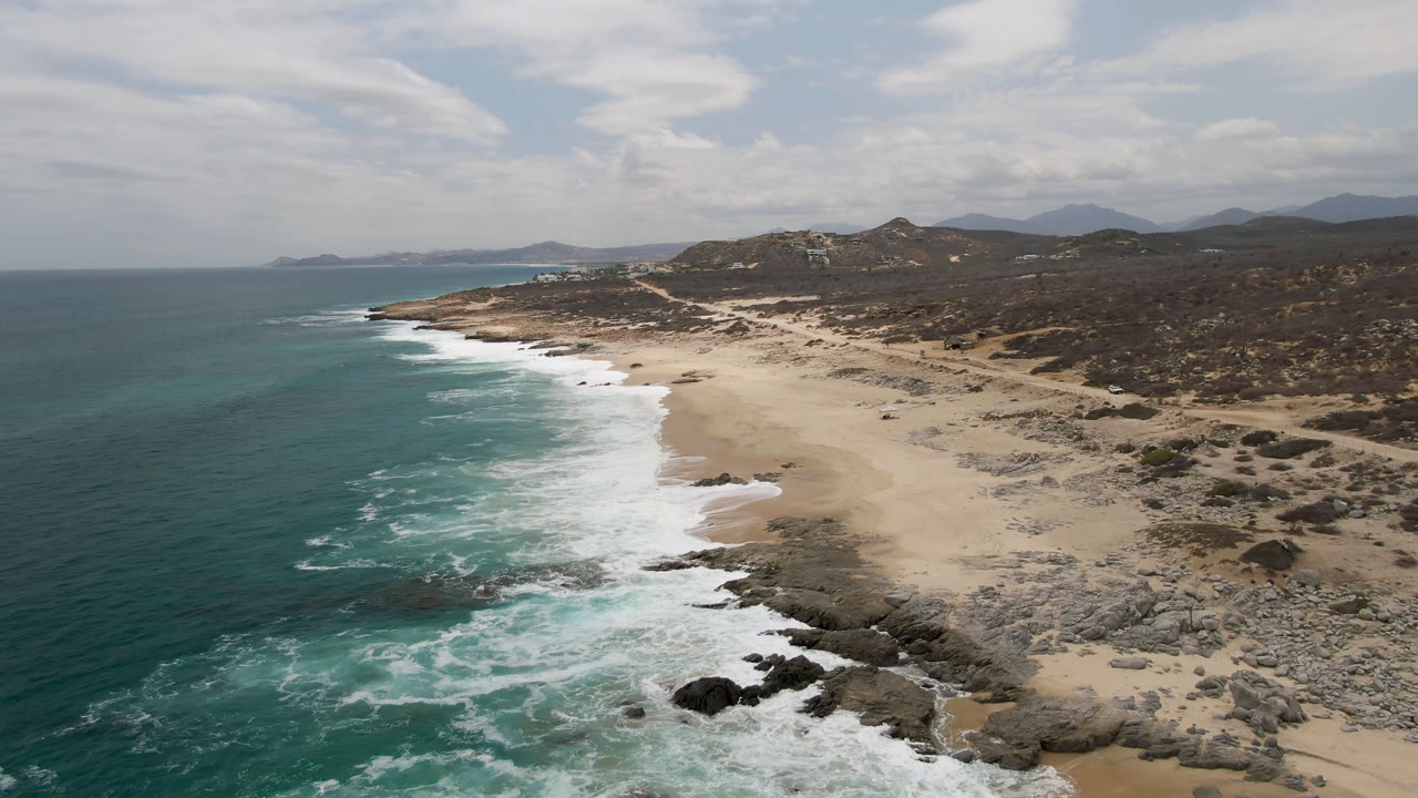 High coastal view with ocean, whitewater, beach, and hills