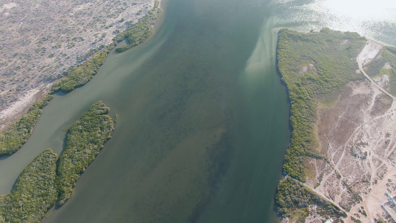 River bend with green marsh strips and dry sandy ground.