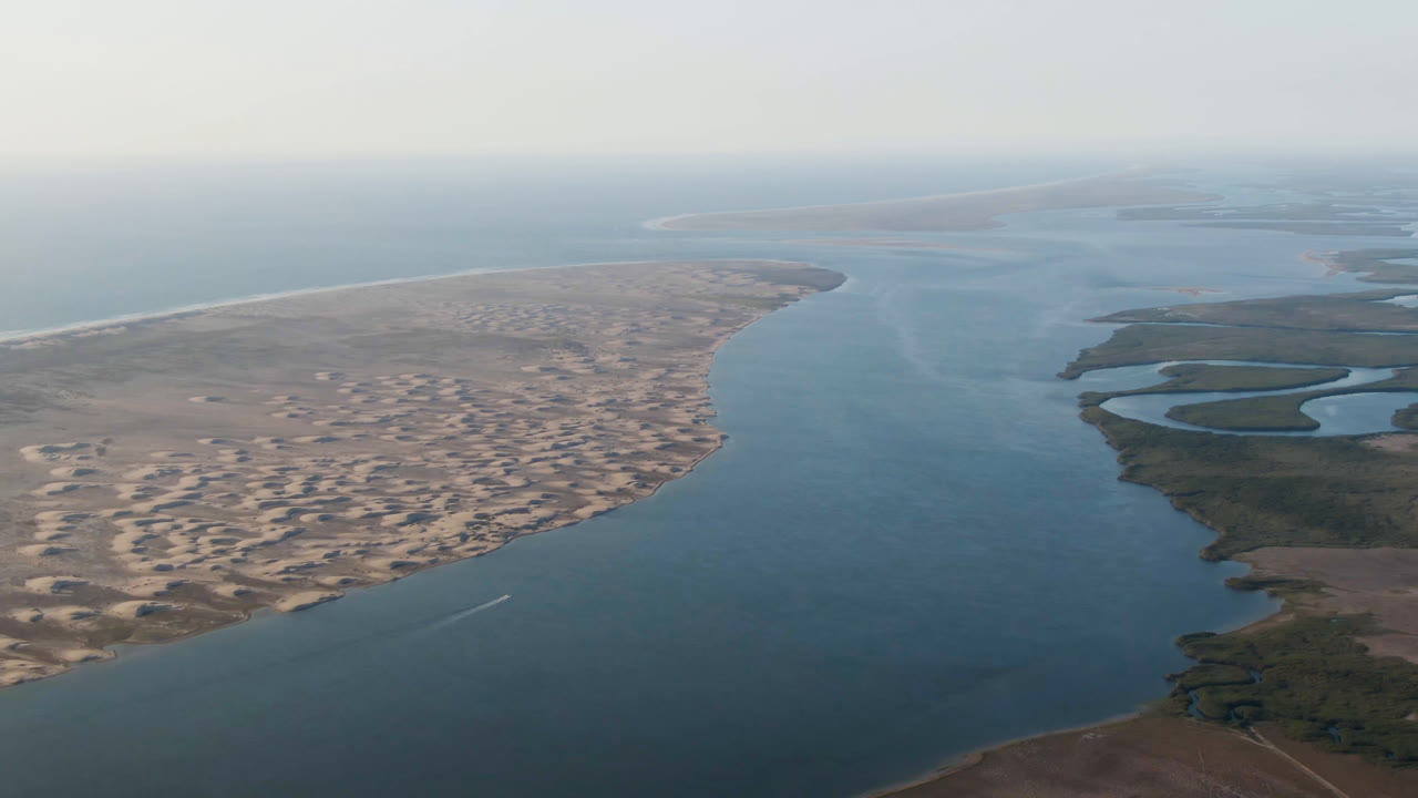 Drone view of shoreline dunes, open water, and marsh inlets