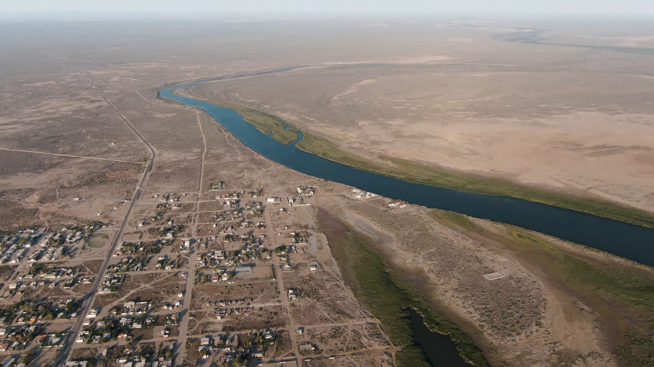 Aerial view of a river beside a small town and dry open land
