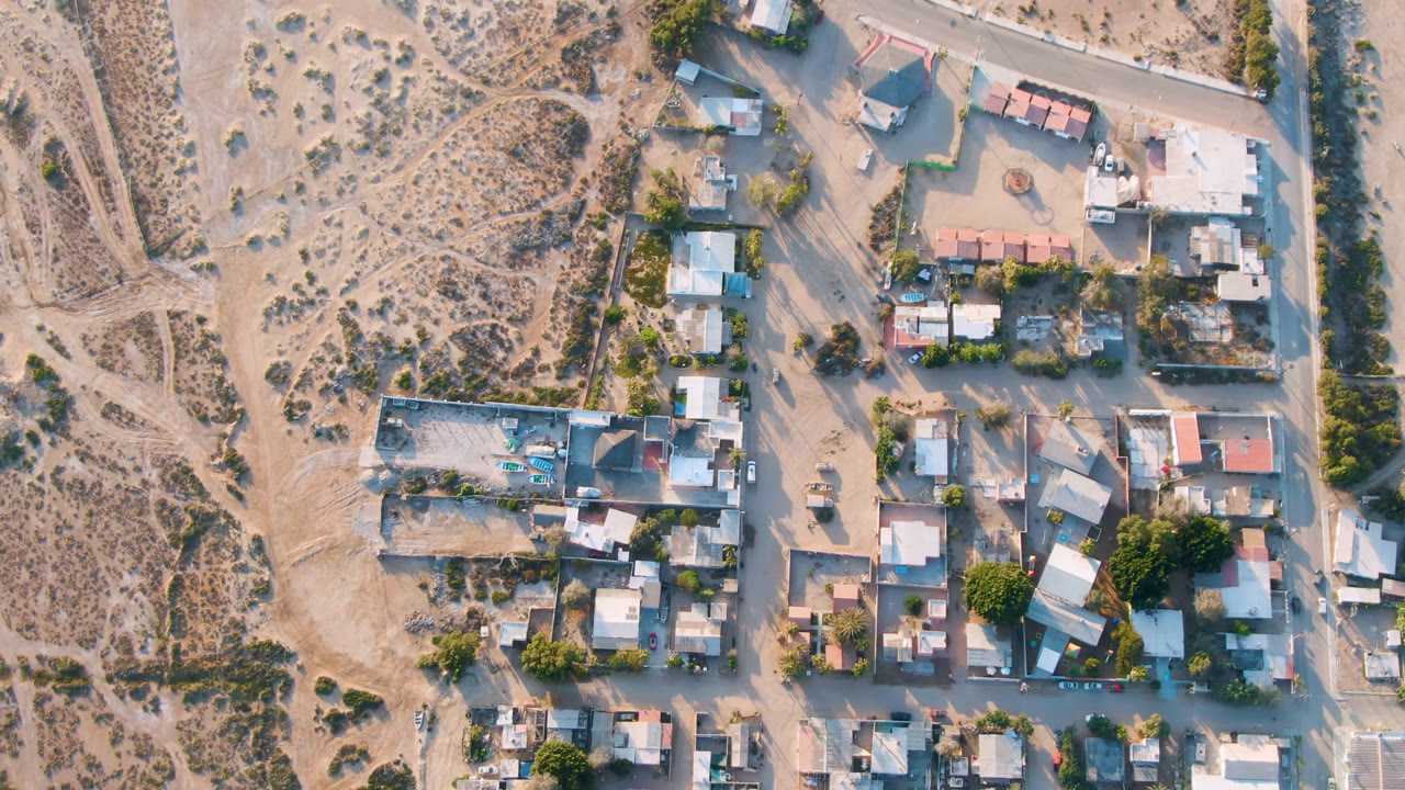 Overhead view of a small town beside dry desert lots.