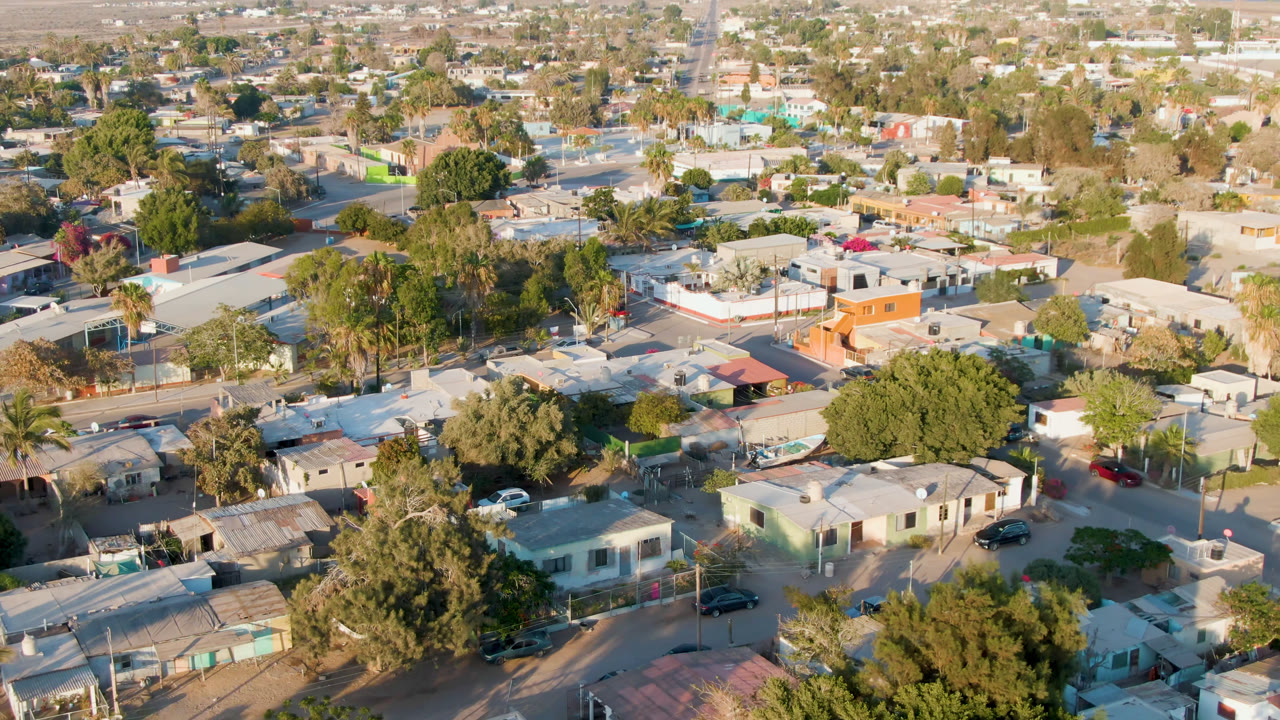 Aerial neighborhood view with an orange building and tree-lined streets.