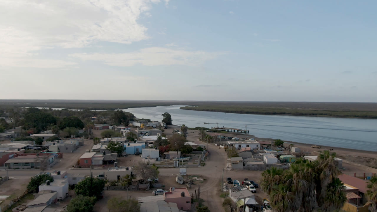 Aerial view of low buildings beside a wide water channel