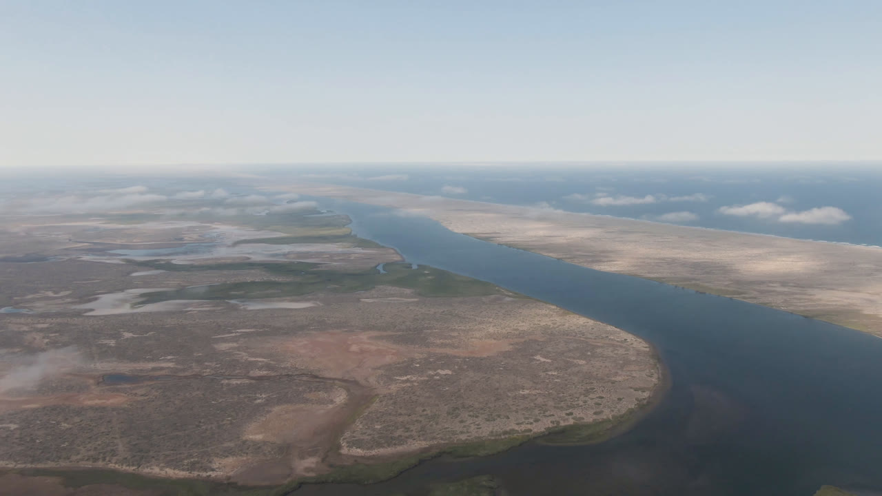 Opening aerial frame over Aldofo Lopez Mateos, Baja California Sur, with a broad river between dry sand flats and no visible people.