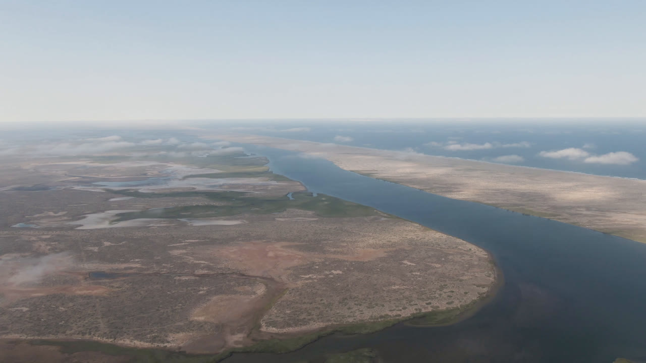 Aerial view in Aldofo Lopez Mateos showing the river stretching toward the horizon with brown scrubland in the foreground and no visible people.