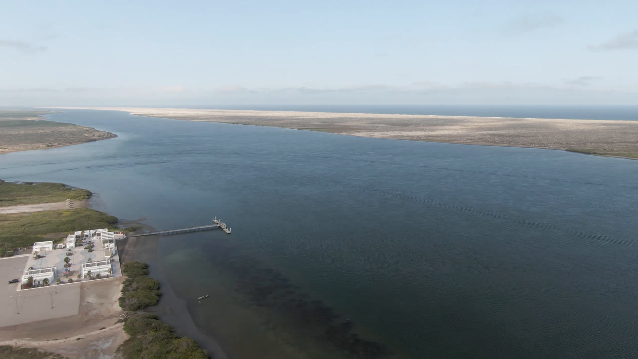 Aerial frame from Aldofo Lopez Mateos showing the dock and shoreline facility slightly farther into view, with open water dominating the center and no visible people.