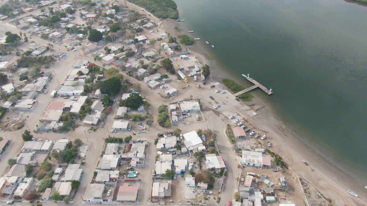 Aerial view of a small town beside green water and a dock
