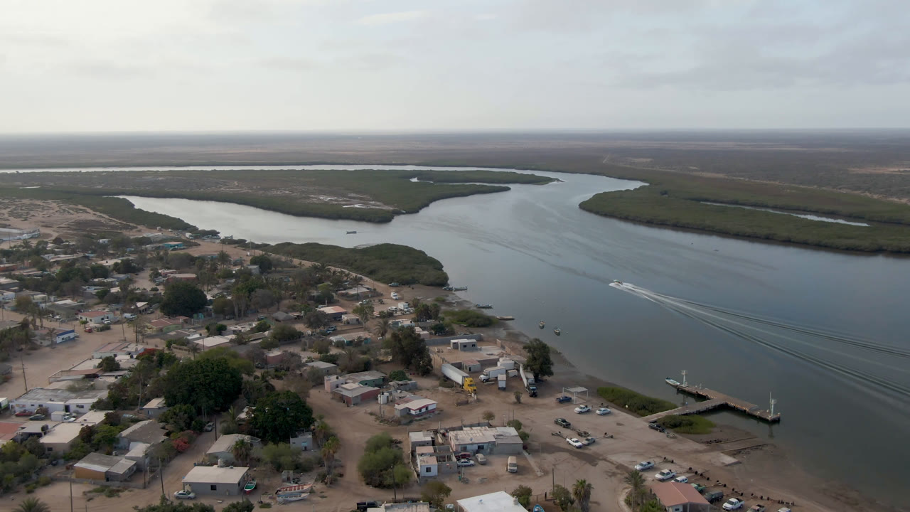 Aerial view of a town beside a wide waterway and marshland.