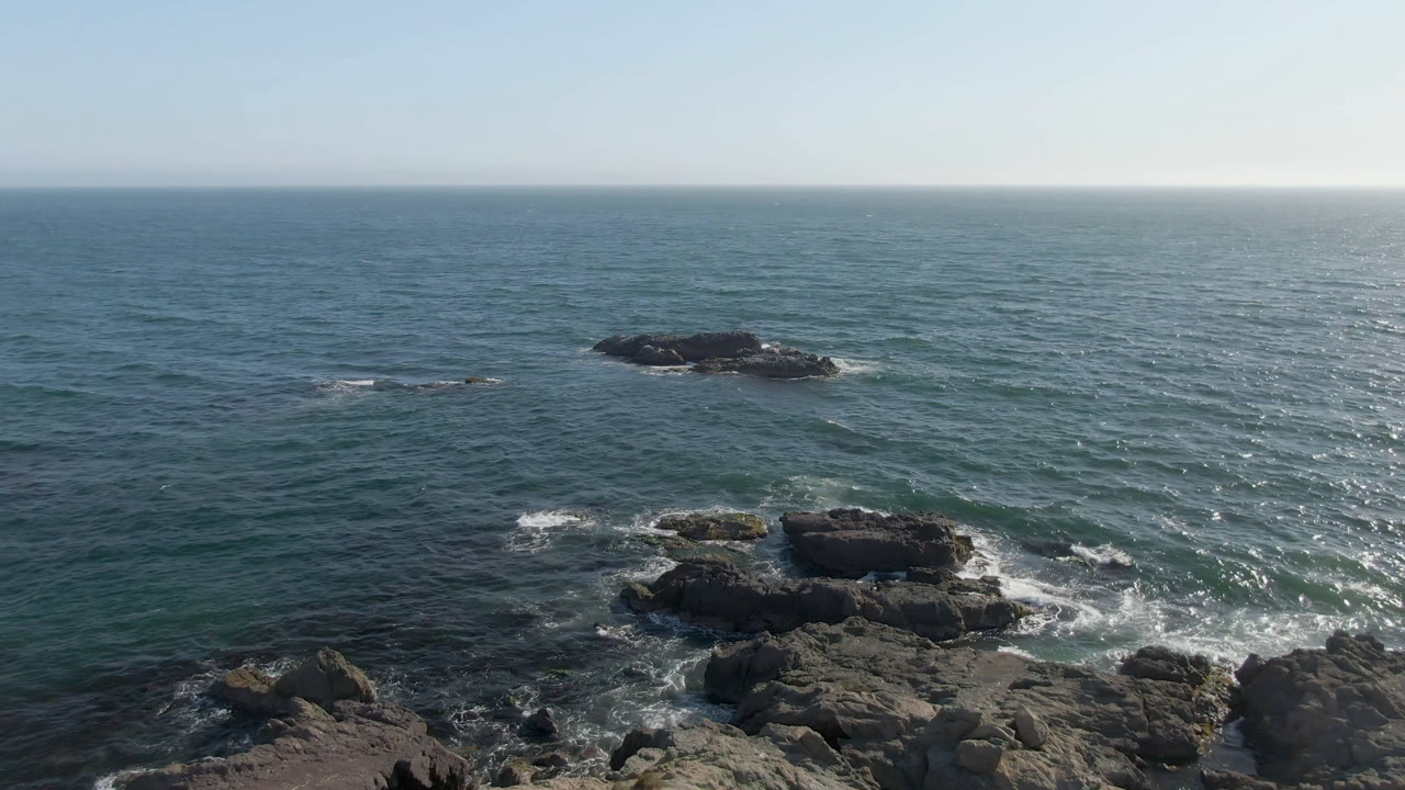 Rocky ocean outcrop beneath a clear sky