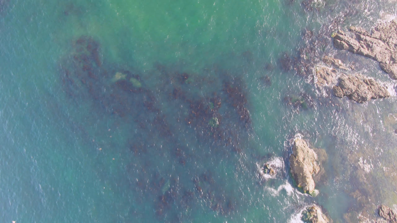 Clear coastal water with rocks entering from the upper right