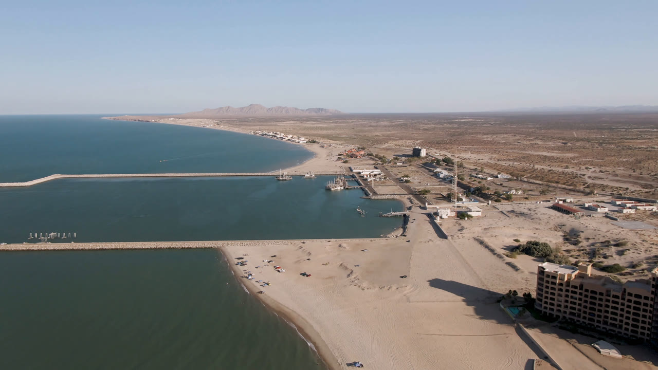 Aerial view of beach, pier, ocean, roads, and desert coastline.