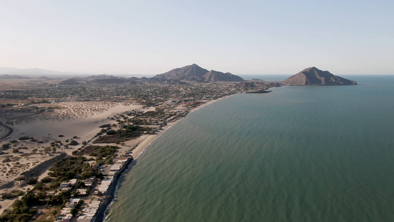 A second over San Felipe, Baja California, Mexico holds a high aerial view of the shoreline, with rippled water, pale sand, scattered buildings, mountains, and no visible people.